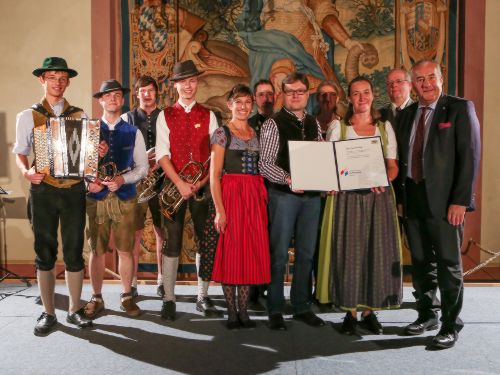 Delegation aus Vertretern der bayerischen Bezirke und Volksmusikanten nehmen Auszeichnung entgegen